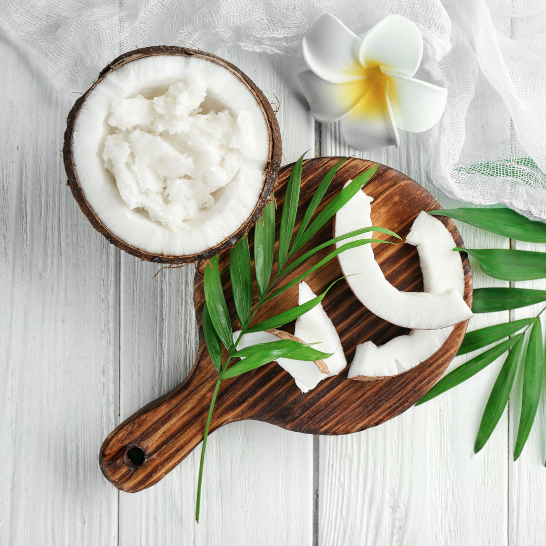 A picture of an open coconut with coconut shavings within the open coconut decorated with a flower.