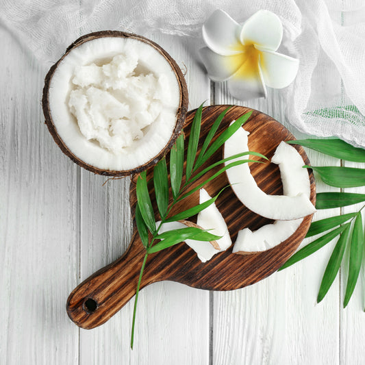A picture of an open coconut with coconut shavings within the open coconut decorated with a flower.